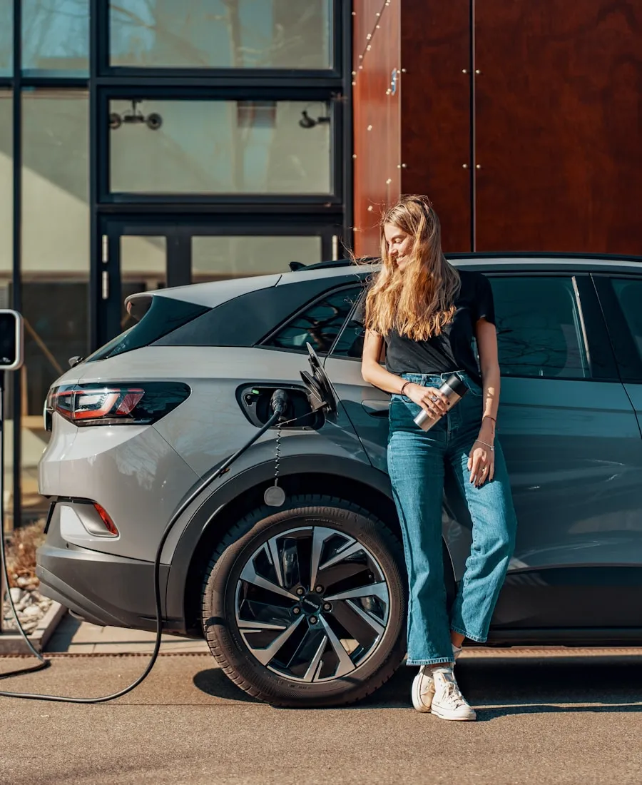 Une conductrice recharge sa voiture électrique devant son logement