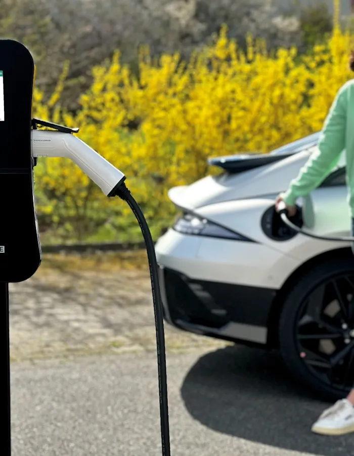 Un installateur pose une borne de recharge murale au domicile d'un particulier